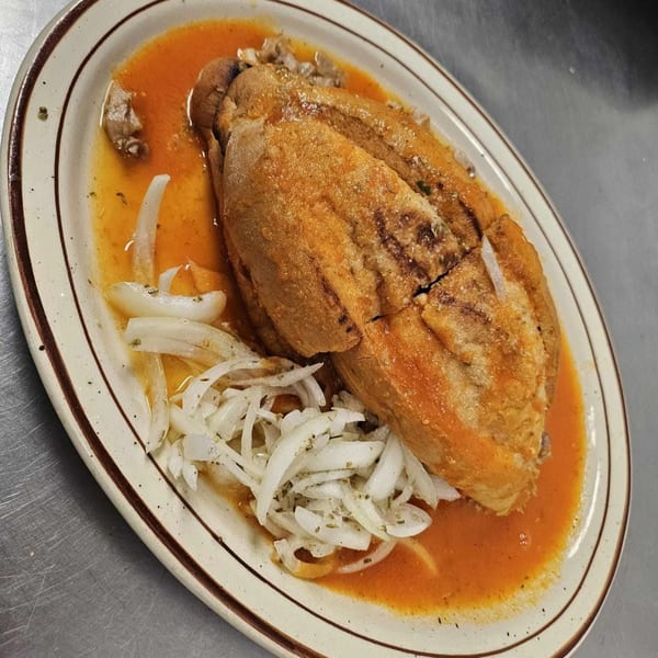 Hacienda Jalisco's pambazo, a Mexican sandwich, drenched in red sauce and topped with sliced onions.