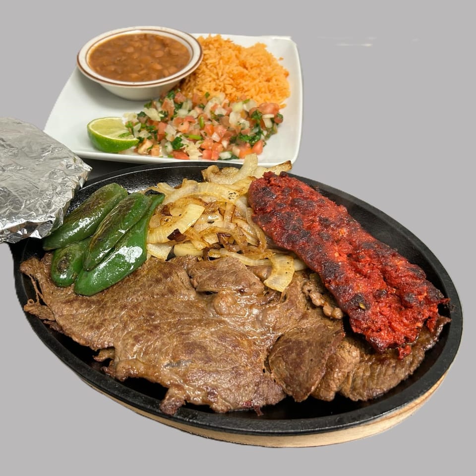 Hacienda Jalisco's sizzling platter with steak, chorizo, grilled peppers, onions, rice, beans, and pico de gallo.